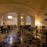 Ci spostiamo nei due vani laterali, che adesso ospitano i tanti tavoli del caff�. Quello di destra, leggermente rialzato, presenta lo stesso pavimento del precedente ed � diviso da una doppia arcata bianca, sorretta da una possente colonna